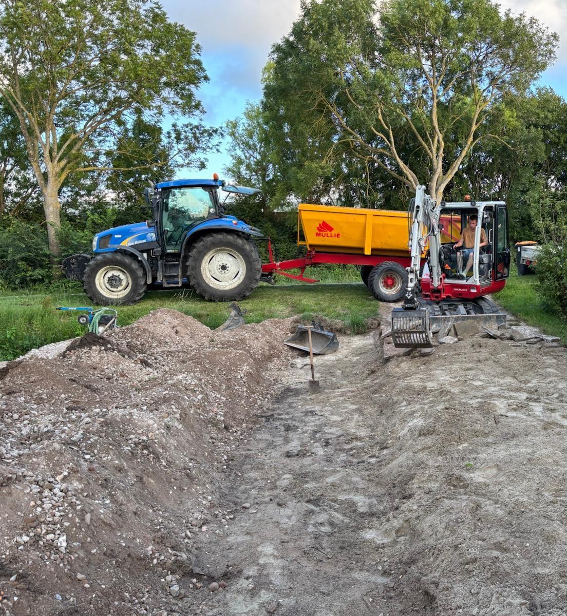 Tractor met kar en graafmachine tijdens een grondwerkklus